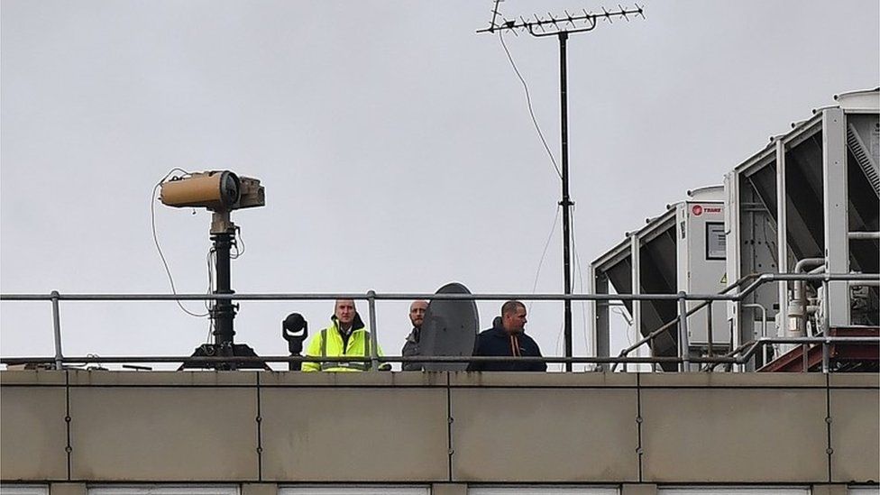 People on the roof of a Gatwick building with equipment
