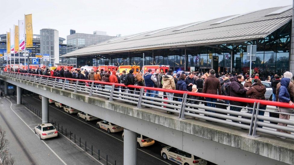 Passengers wait outside of Hamburg airport