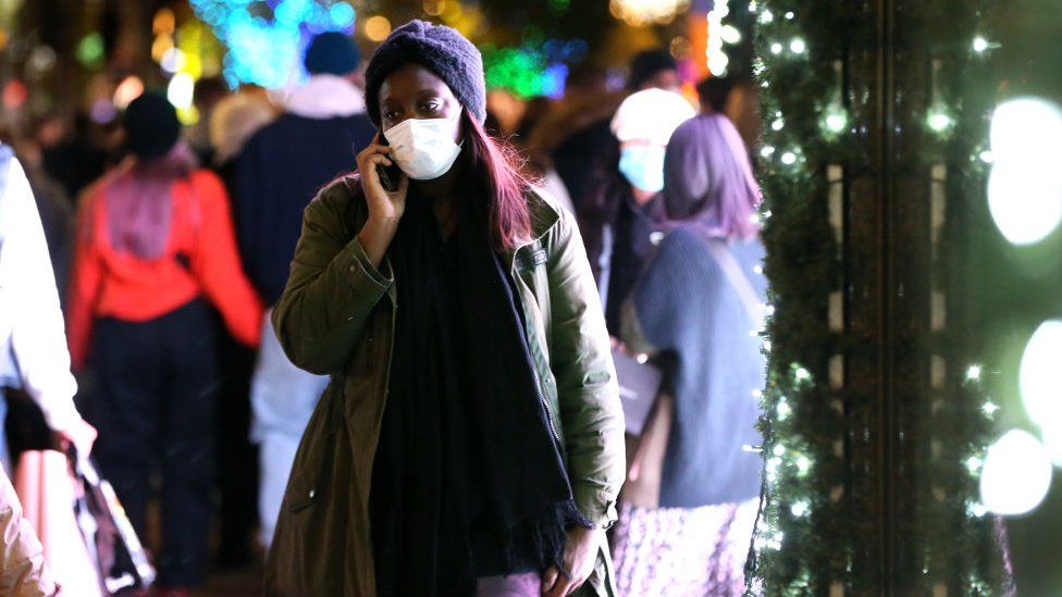 A woman wears a facemask as she walks in London