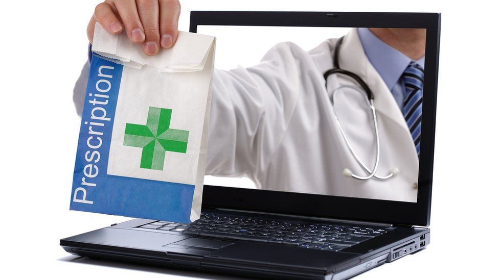 Pharmacist handing bag of drugs through laptop screen