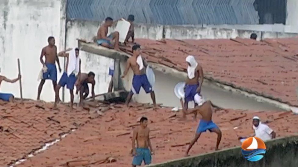 This grab from TV Ponta Negra shows inmates throwing objects from the prison roof during a riot.