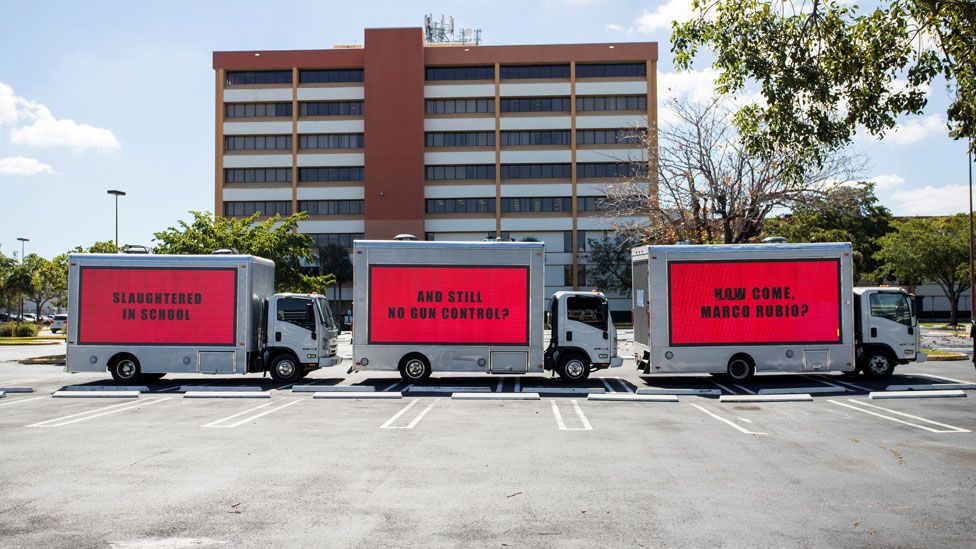 Three vans bearing billboards in Miami