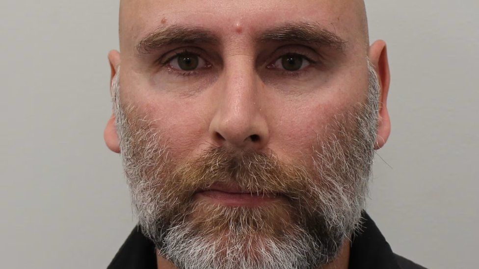 Police custody image of Nathan Arnold, a bald man with a beard