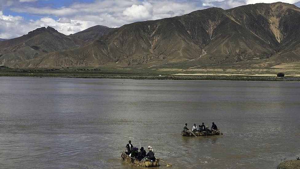 Tibetan people row cowskin rafts on the Brahmaputra River on August 30, 2006 in Renbu County of Tibet Autonomous Region, China. Cowskin is a traditional material used to make rafts for fishing and to cross rivers and lakes for the Tibetan peole.