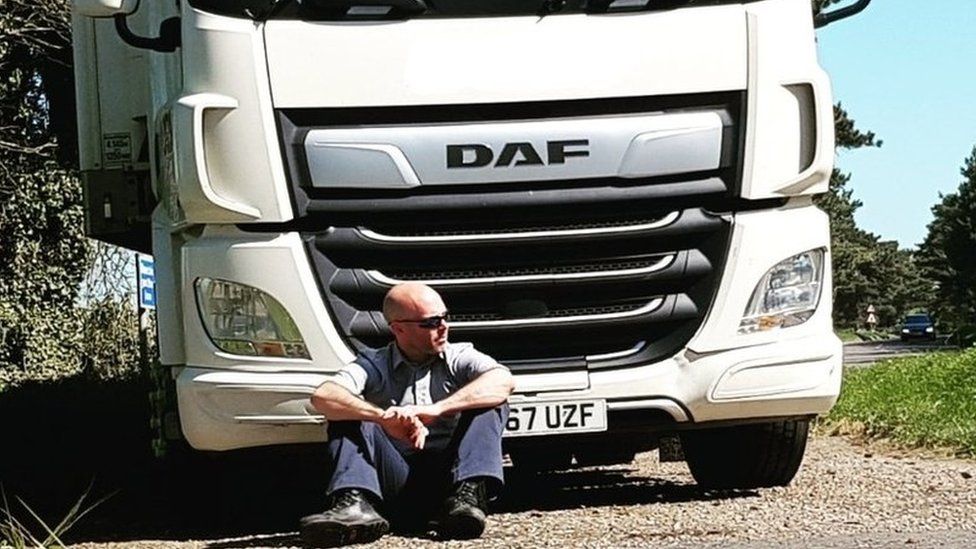 Tom Reddy sat in front of a parked lorry