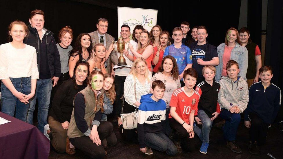Erwood YFC Cast members being presented with the winning trophy at the Brecknockshire YFC panto finals