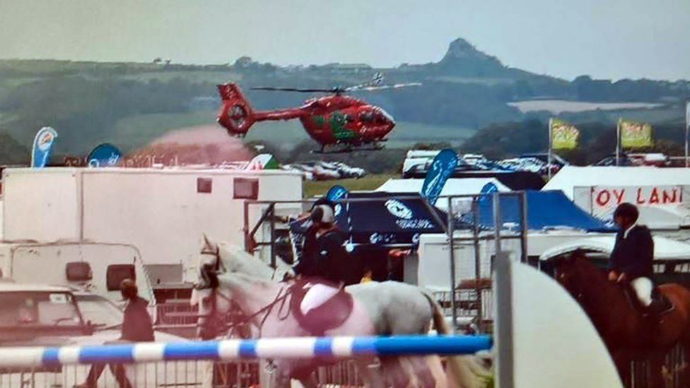 Air ambulance in the background of the show with horses in the foreground