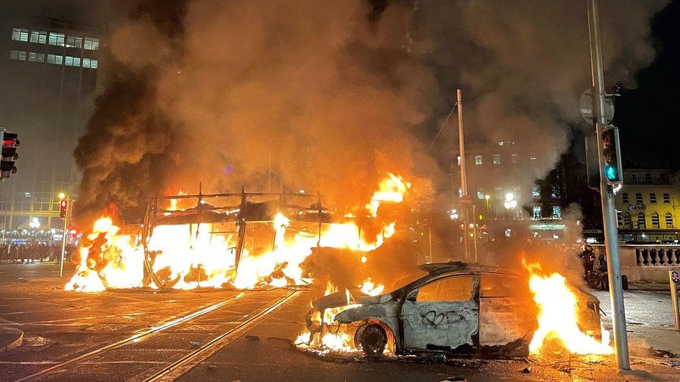 A bus and car on fire on O'Connell Street in Dublin city centre after violent scenes following a knife attack