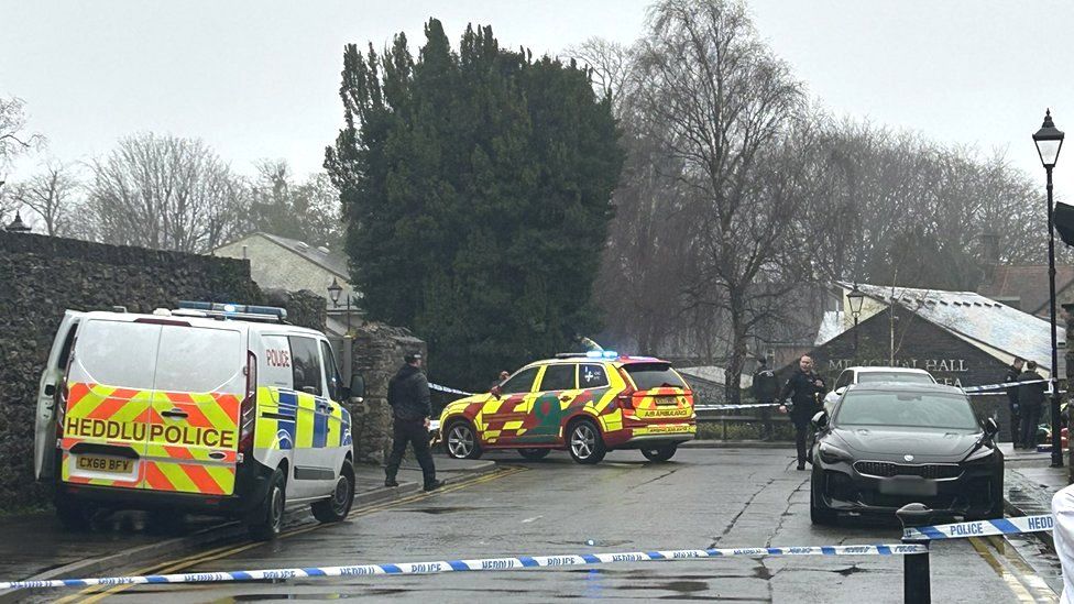 Police officers and police tape blocking a road in Llandaff, Cardiff