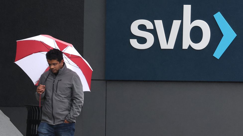 Employees walk in front of the Silicon Valley Bank (SVB) headquarters in California