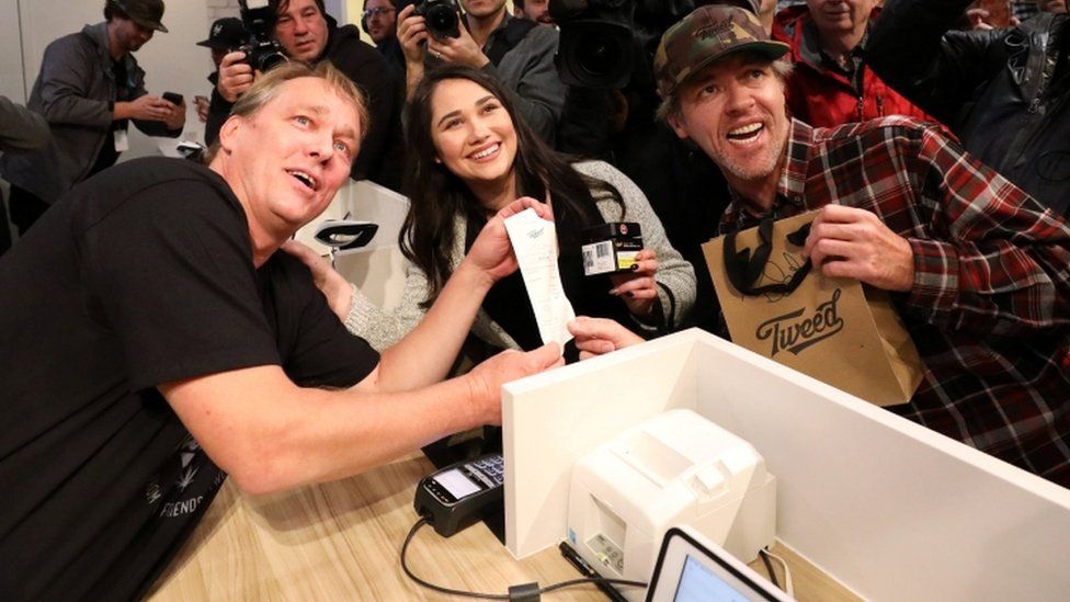 Customers Nikki Rose (centre) and Ian Power (right) with Canopy Growth CEO Bruce Linton (left) at Tweed in St John's Newfoundland, 17 October 2018