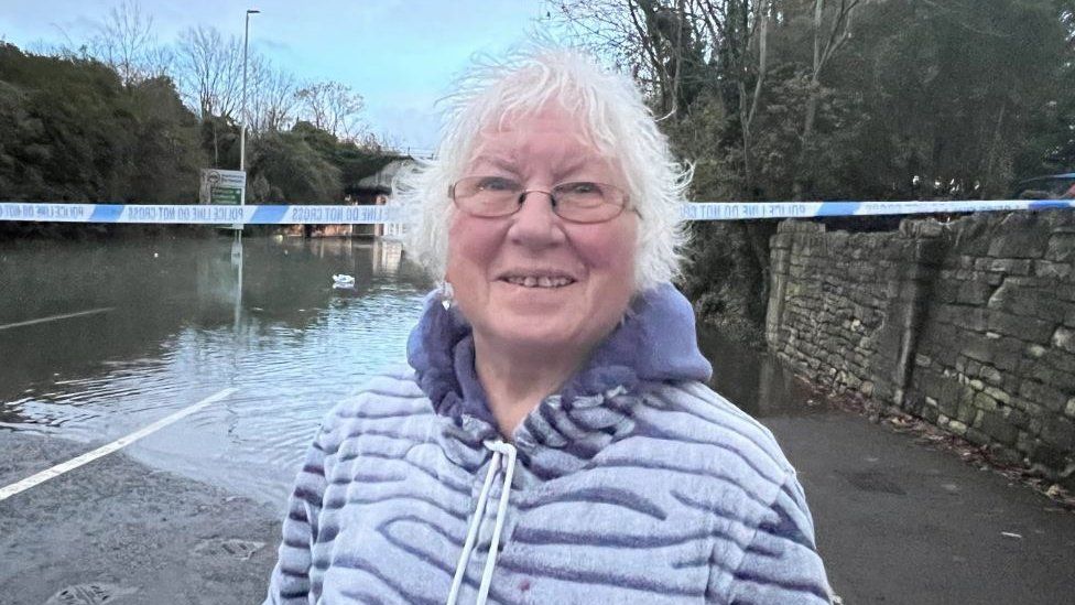 A women standing in front of a flooded road