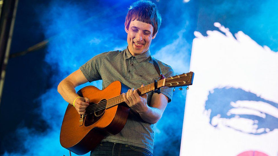 Gerry Cinnamon on stage at T in the Park with an acoustic guitar