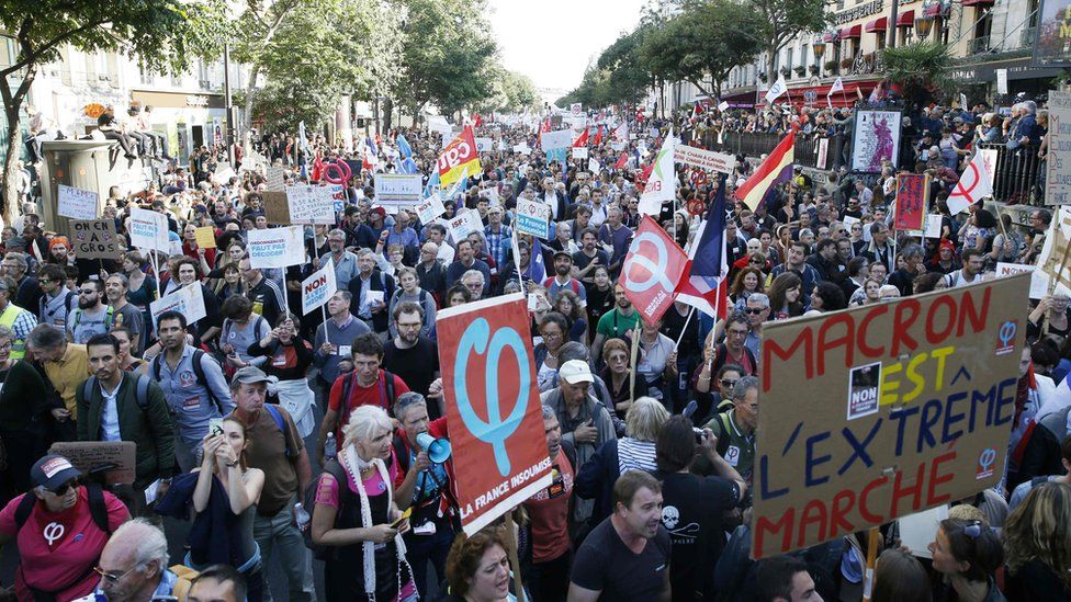 People hold flags of leftist La France Insoumise (France Unbowed) during a protest over the government's labour reforms in Paris, 23 September 2017