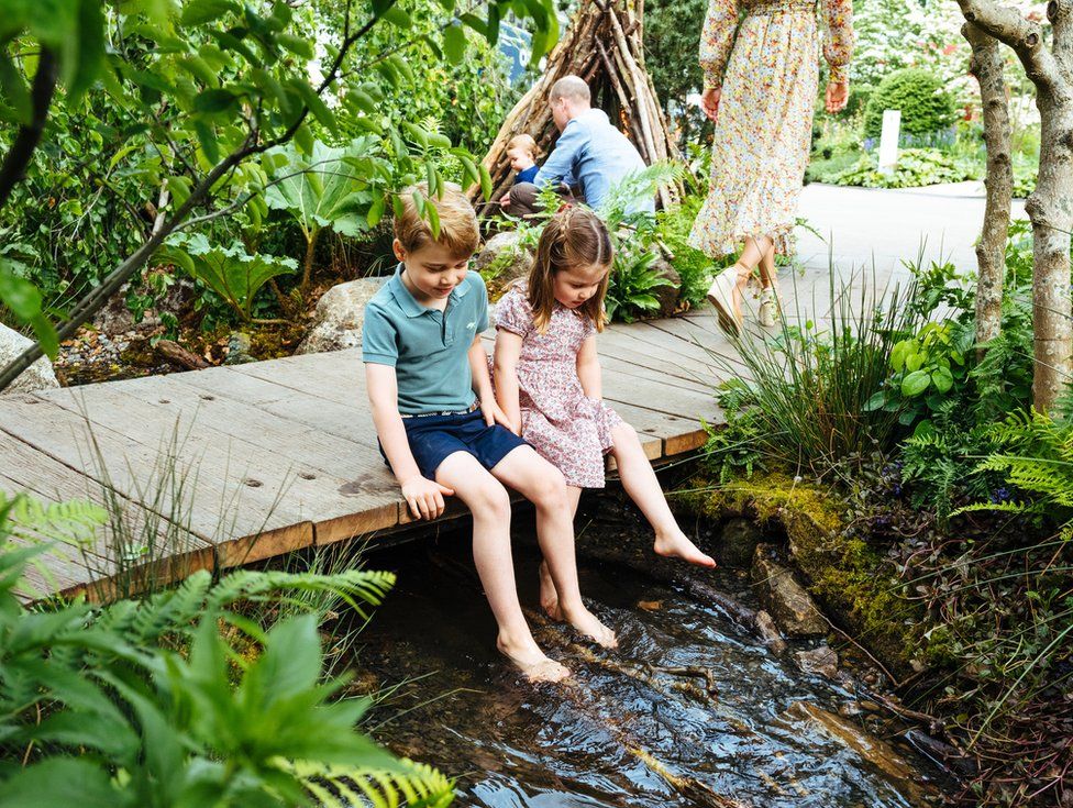 Prince George and Princess Charlotte dangle their legs over the stream