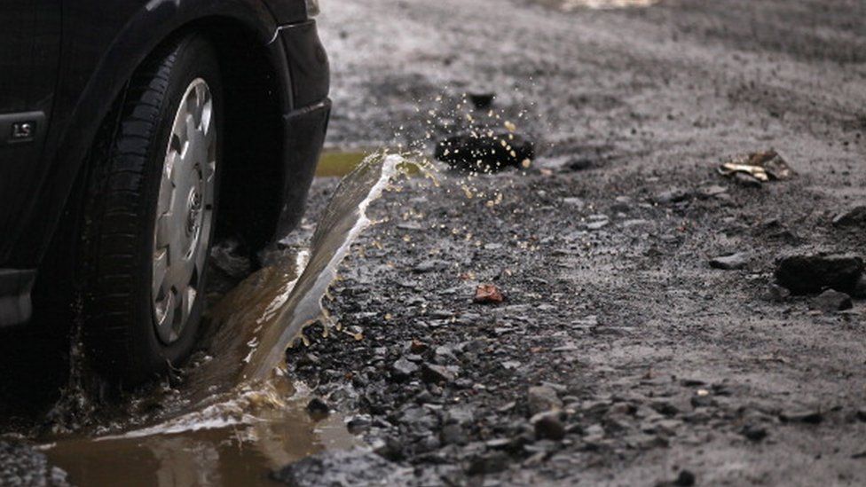 A car driving through a pothole