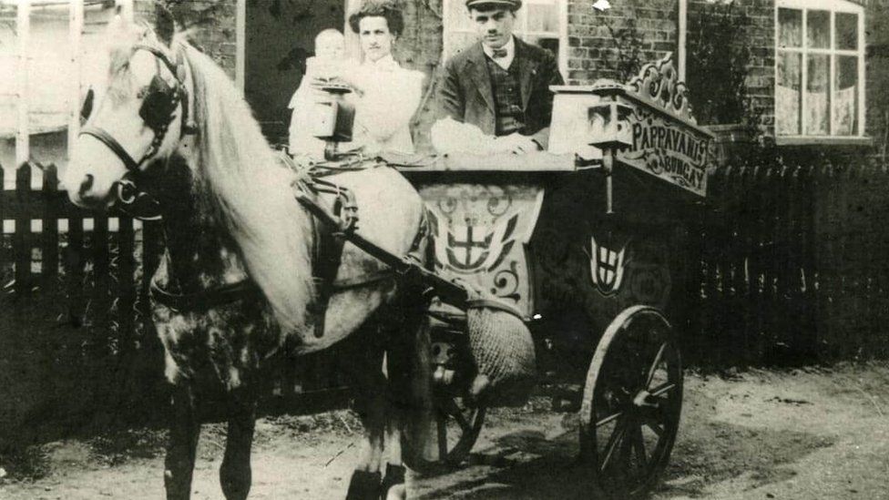 Black and white photo of couple on ice cream carriage