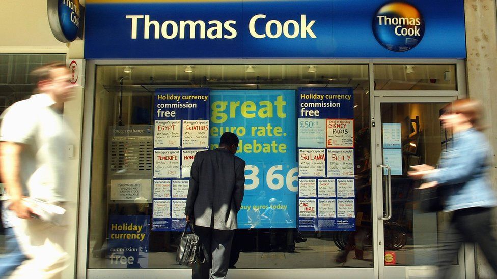 A man looks at the window display of travel agency Thomas Cook July 28, 2003 in London, England.