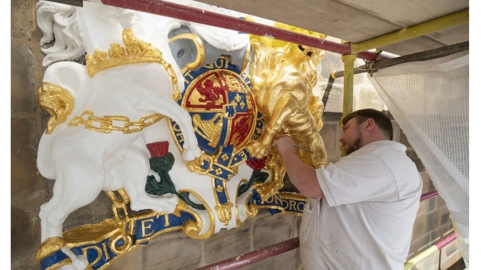 Colin Morris, from Nevin of Edinburgh Painters, applies gold leaf to one of the royal coats of arms during renovation work on the main facade of Canongate Kirk in Edinburgh.