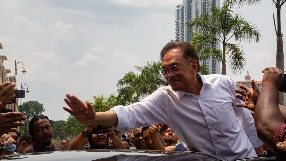 Malaysian politician Anwar Ibrahim waves to his supporters outside the headquarter of People