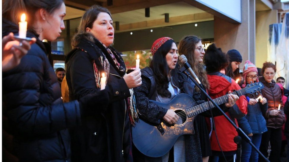Some of the group, with adults, play music at vigil