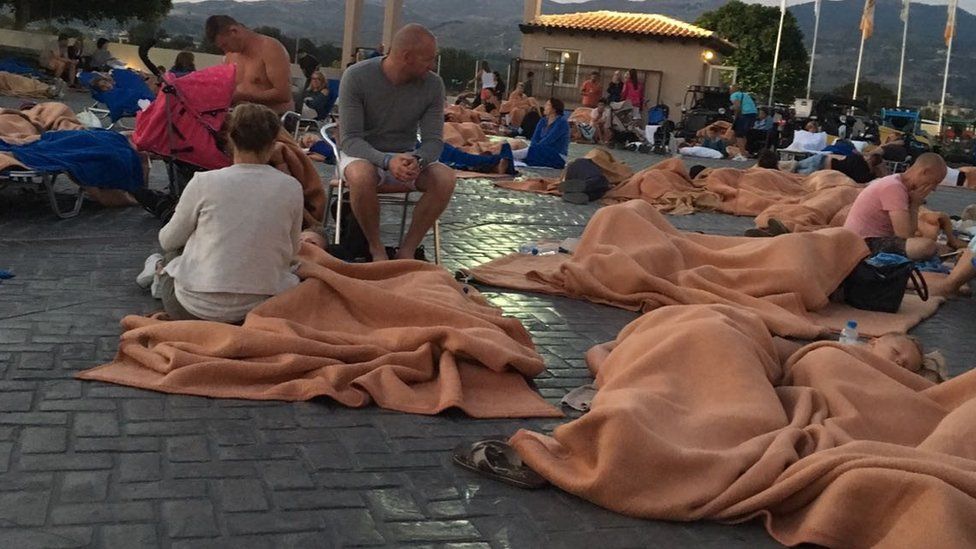 Holidaymakers sleep outside under blankets