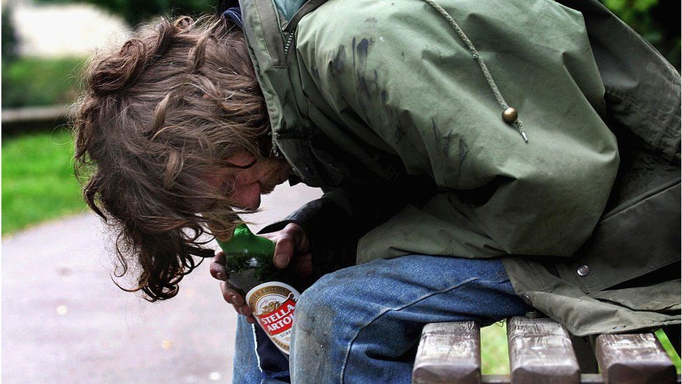 File photo shows a homeless man with a bottle of alcohol