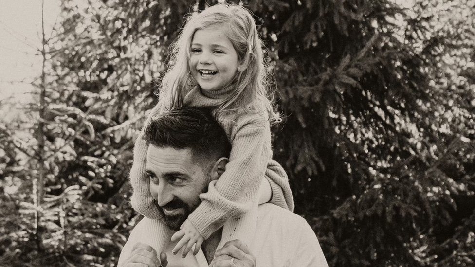 Black and white photos of James Marks with his daughte ron his shoulders