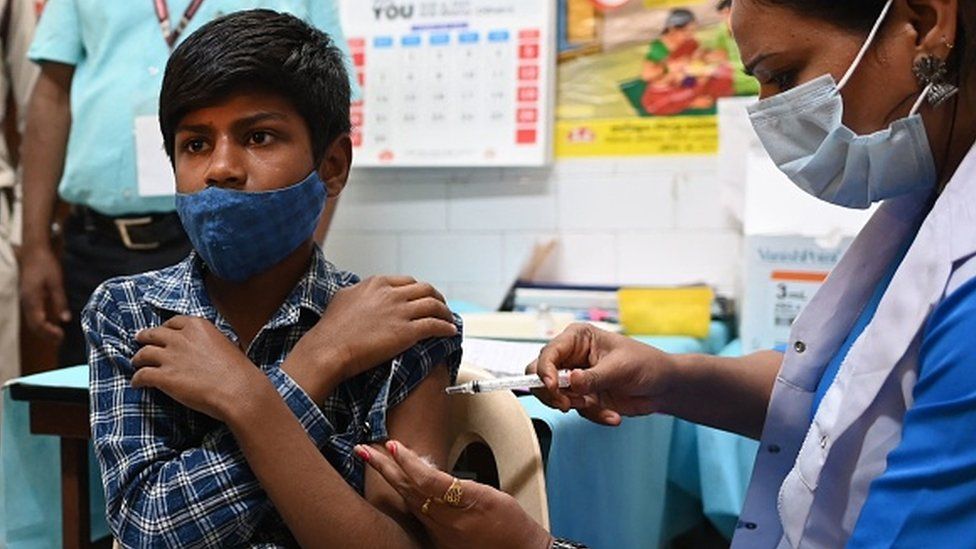 A health worker inoculates a teen with a dose of a Covid-19 Corbevax vaccine in New Delhi on 16 March 2022.