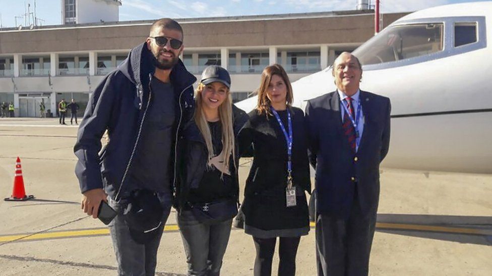 Gerard Piqué (left) alongside his wife, Shakira, and airport staff in Rosario