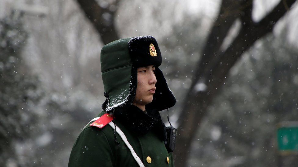 A paramilitary police officer stands guard during a snowfall ahead of a welcoming ceremony held by Chinese Premier Li Keqiang for the French Prime Minister Bernard Cazeneuve near Tiananmen Square in Beijing, China. February 21, 2017.