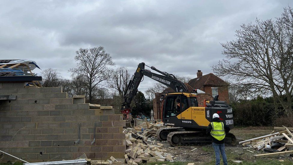 A digger is demolishing the Captain Tom spa building