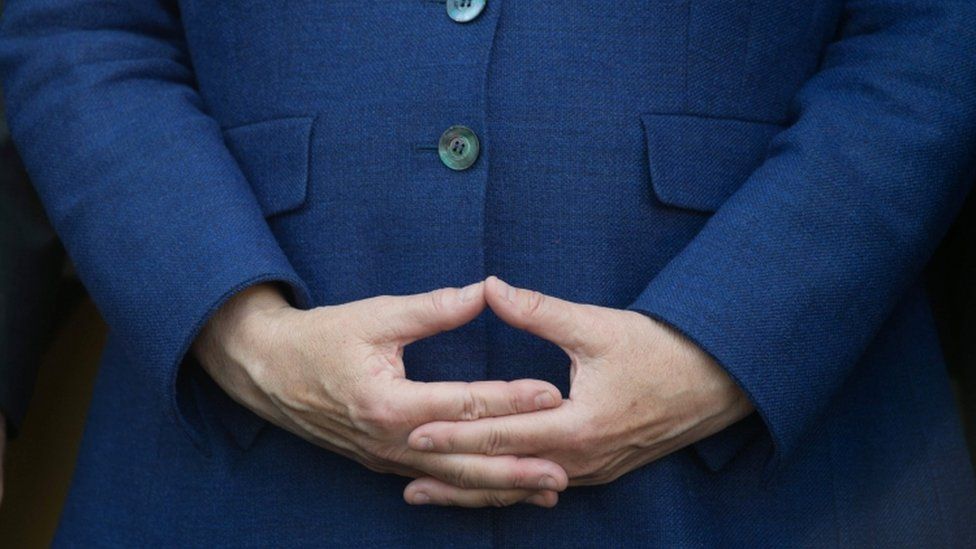 Merkel holds her hands in signature position during a rally. Close up shot of the hands.