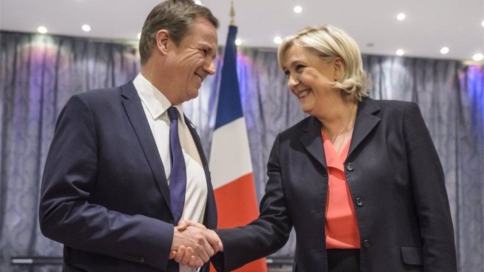 Nicolas Dupont-Aignan (L) and Marine Le Pen (R) shake hands after delivering a joint news conference in Paris, France (29 April 2017)