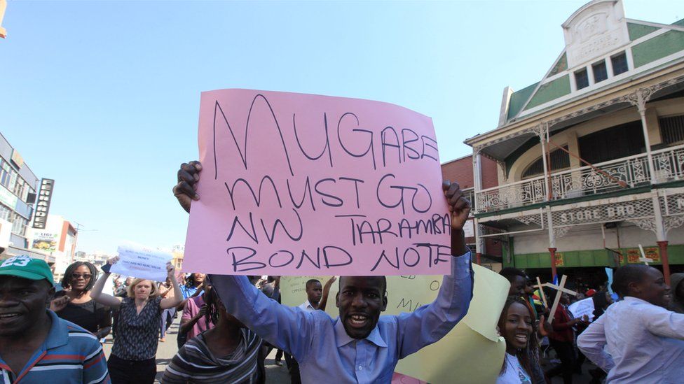 Protesters in Harare, Zimbabwe, one holding a "Mugabe must go" sign - Wednesday 3 August 2016
