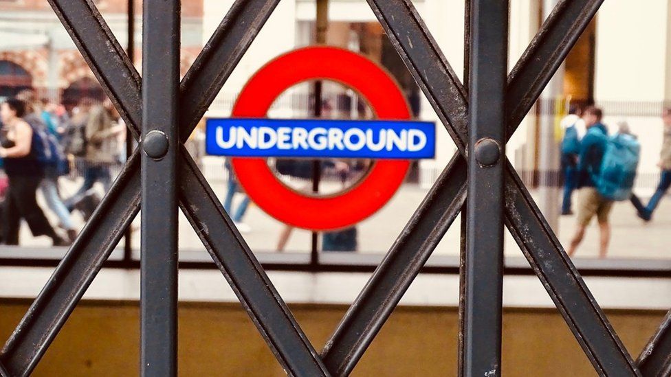 Image showing a Tube roundel seen done  holes successful  a closed entranceway  gate.