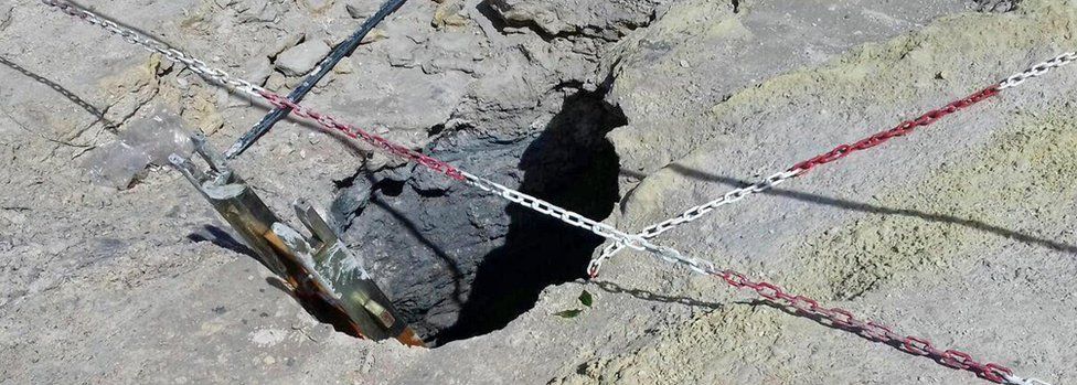 The hole in the crater was visible along with the chains that rescuers had used to reach the three victims