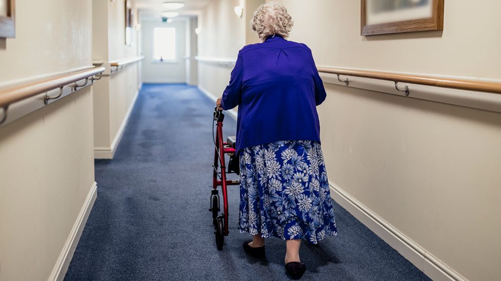 Stock image of a woman in the corridor of a care home