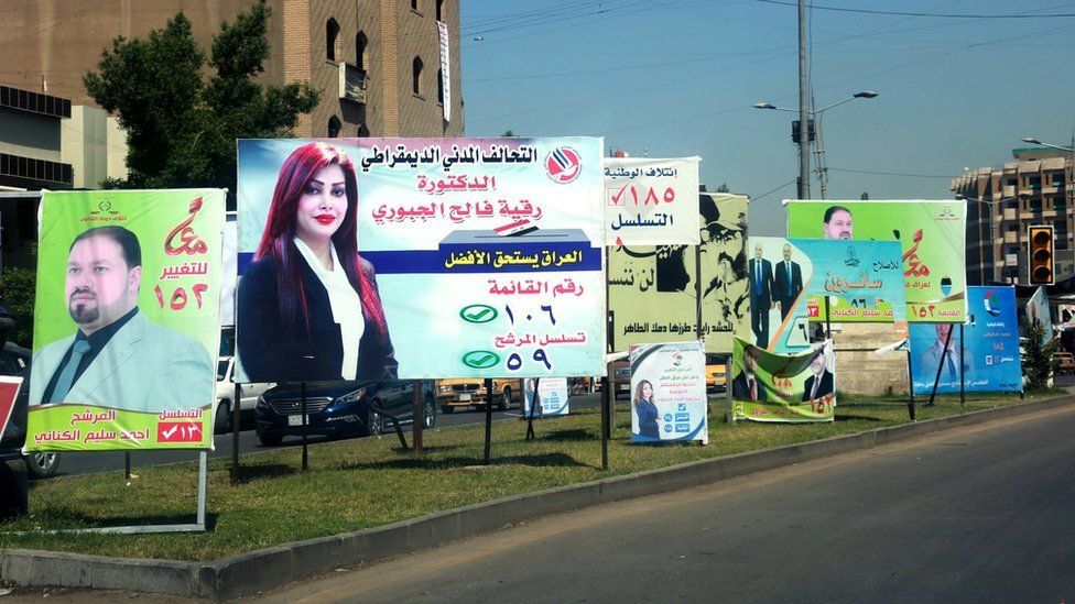 Election posters featuring men and women are seen in Baghdad, Iraq, on 19 April