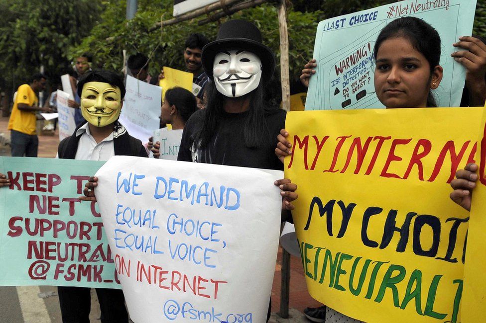 Indian activists wear masks as they hold placards during a demonstration supporting 'net neutrality' in Bangalore