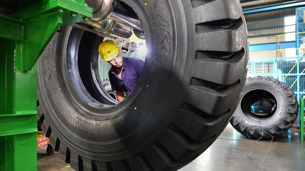 An Indian employee checks tyres for faults at the JK Tyre and Industries manufacturing plant in Mysore