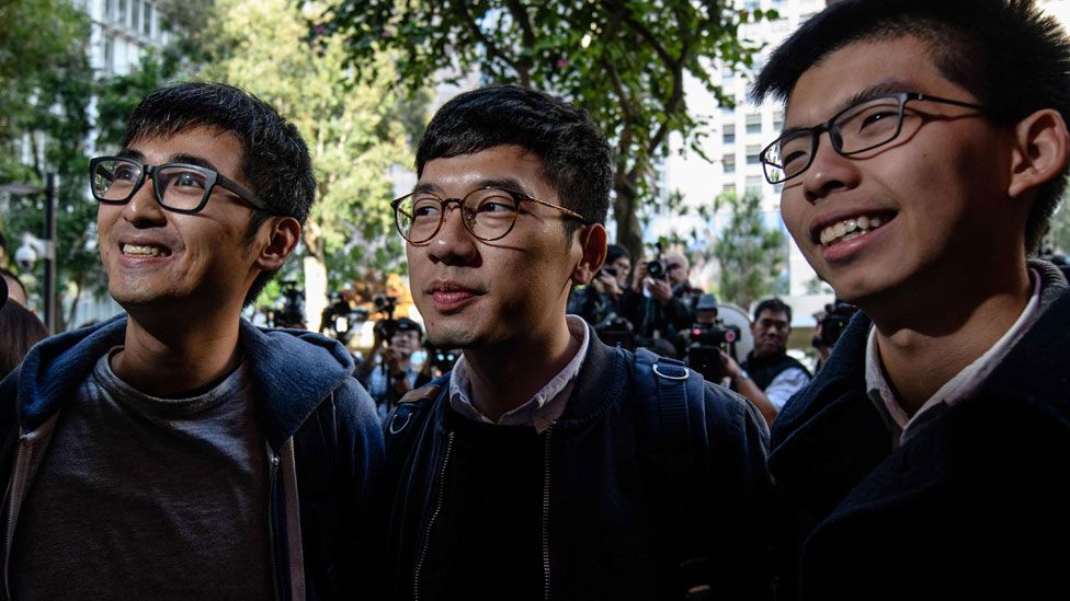 Three young men smile outside the court in Hong Kong earlier in January