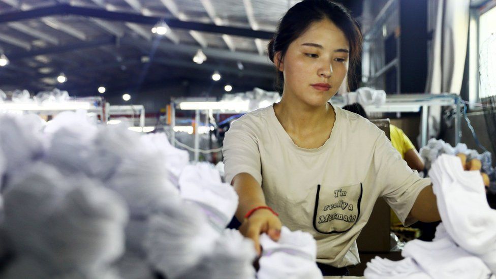 A woman works on socks that will be exported to the US at a factory in Huaibei in China's eastern Anhui province on August 7, 2018.