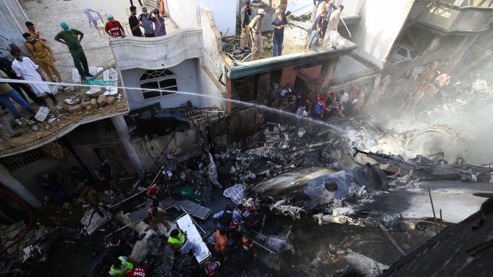 人们俯视PK8303航班燃烧的残骸
