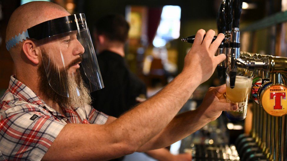 A bartender pours beer at a bar in Belfast