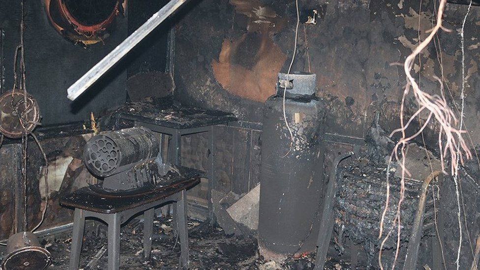 Charred cylinder and heater after fire