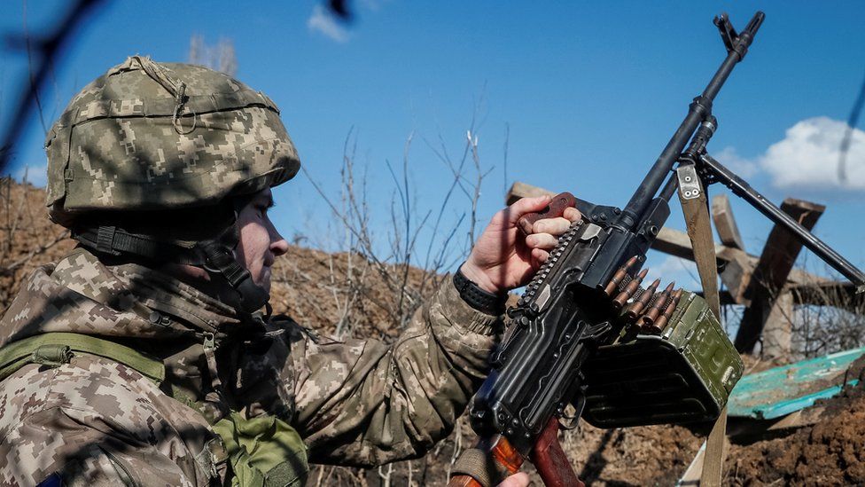 A Ukrainian serviceman holds a machine gun at a town in Donestsk