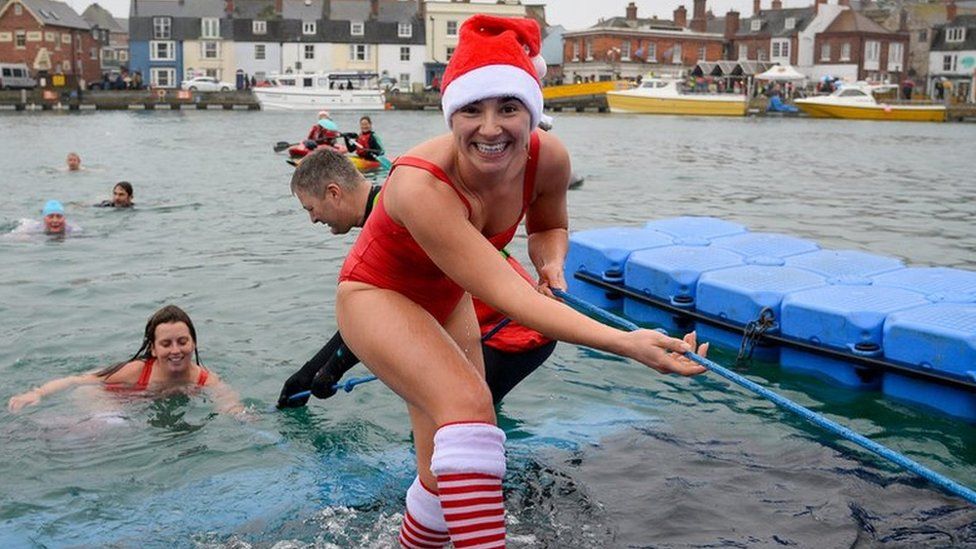 swimmers taking the plunge during the annual Christmas swim in Weymouth, Cornwall, UK