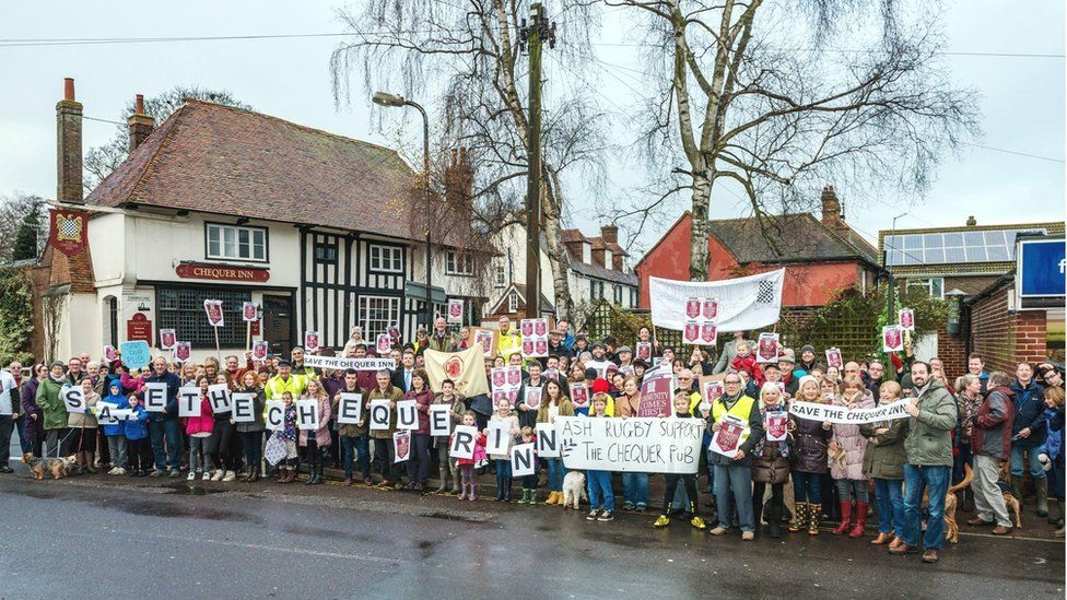 Community members celebrate outside an old half-timbered pub
