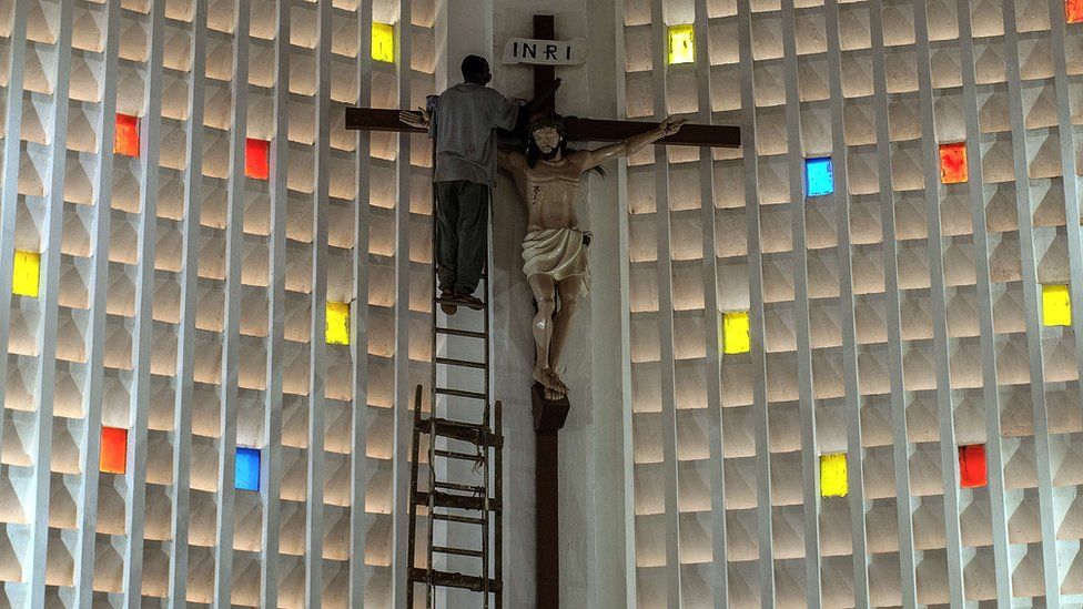 Carpenter cleaning a crucifix in Cathedral Notre Dame, Bangui, CAR - Wednesday 25 November 2015